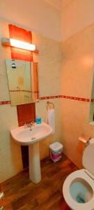 La salle de bains est pourvue d'un lavabo et de toilettes. dans l'établissement Tranquille Homestay near JKIA Airport & SGR Station Nairobi, à Nairobi