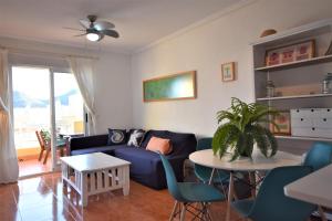 パロス岬にあるCala Reona Apartamentosのリビングルーム(青いソファ、テーブル付)