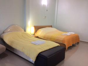 Briya Beachfront Residence في سيتشون: سريرين في غرفة مع مسند بينهما