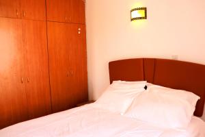 a bedroom with a bed with a wooden headboard at Silent Sky Homestay near JKIA Airport & SGR Nairobi in Nairobi