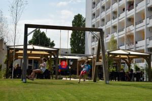 Hotel Cometa في جوبيتر: بنتان يلعبان على أرجوحة في حديقة