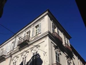 wysoki biały budynek z oknami i niebieskim niebem w obiekcie La Casa Di Cocca w Albie