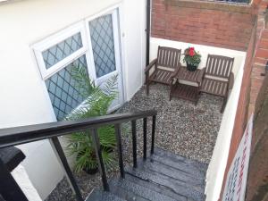 eine Treppe mit zwei Stühlen und einem Tisch mit Blumen in der Unterkunft Novello Blackpool in Blackpool