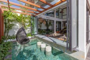 an indoor pool with a hammock in a house at Beyond Bespoke Villas in Seminyak