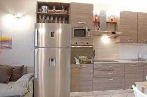 a kitchen with a stainless steel refrigerator at Condominio Le Palme in Santa Teresa Gallura