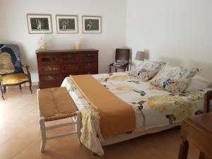 - une chambre avec un lit, une commode et une chaise dans l'établissement Mas du Cheval Long, à Sablet