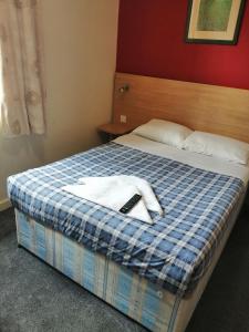 Una habitación de hotel con una cama con una toalla. en Colliers Hotel, en Londres