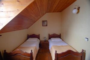 two beds in a room with a attic at Milorava's Guest House & Wine Cellar in Tʼelavi