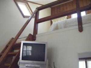 Habitación con TV y escalera con TV y calentador de toallas. en Moffett House Inn, en Provincetown