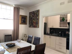 cocina y comedor con mesa y sillas en Sandton Luxury Living at 102 Kambula, en Johannesburgo