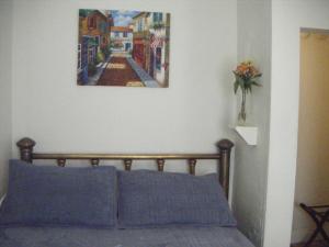 1 dormitorio con 1 cama con una pintura en la pared en Moffett House Inn, en Provincetown