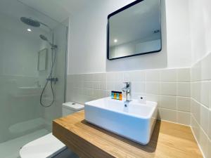 a bathroom with a tub, toilet, sink and mirror at Hotel Casa Miranda in Mahón
