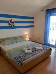 a bedroom with a bed with two pillows on it at Apartmani Elena in Malinska