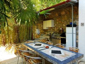 a kitchen with a table with chairs and a refrigerator at Apartmani Elena in Malinska