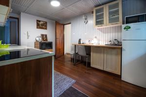 cocina con suelo de madera y nevera blanca en Bagry Rooms, en Cracovia