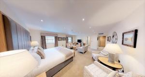 a bedroom with a large bed and a living room at The H Boutique Hotel in Bakewell
