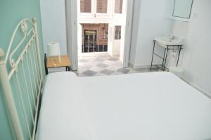 1 dormitorio con 1 cama y pasillo con ventana en Pensión Las Cuatro Naciones en Cádiz