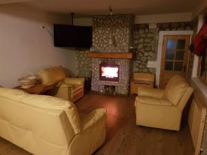 ein Wohnzimmer mit Sofas und einem Kamin in der Unterkunft Modern mountain village chalet in Carpathians in Lereşti