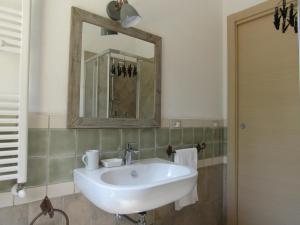 bagno con lavandino bianco e specchio di L’ Angolo degli Ortaggi a Sassari