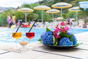 un tavolo con un piatto di fiori e bicchieri di vino di Camping Villaggio Calanovella a Piraino