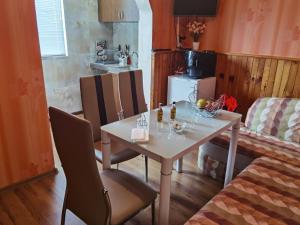 a dining room with a table and chairs and a kitchen at Апартамент ДАНИ in Kazanlŭk
