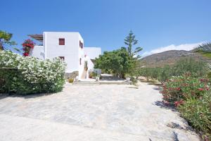 a path leading to a white building with flowers at Villa Katapoliani No.3 in Katapola