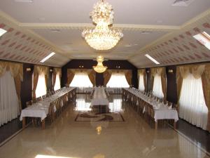 un salón de banquetes con filas de sillas y una lámpara de araña en Weekend, en Mukácheve