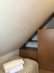 - un lit mansardé avec 2 oreillers dans l'établissement Apartament Łapacz Snów, à Tylicz