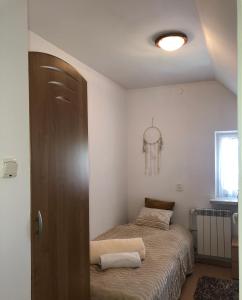 1 dormitorio con 1 cama y puerta de madera en Apartament Łapacz Snów en Tylicz