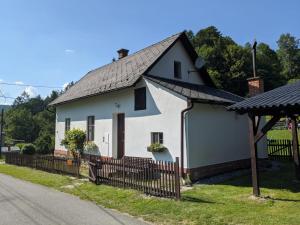 una casa blanca con techo negro en Chaloupka na konci světa, en Ves Raškov