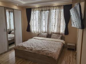 Schlafzimmer mit einem Bett vor einem Fenster in der Unterkunft Апартамент ДАНИ in Kasanlak