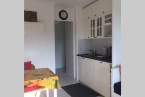 a kitchen with a table and a clock on the wall at La Petite Cachette - Pool and 150m to the beach in Villefranche-sur-Mer