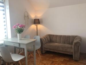 a living room with a couch and a table and chairs at Apartament Łapacz Snów in Tylicz