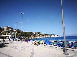 persone sedute su una spiaggia con ombrelloni e l'oceano di Appartamenti Acquazzurra a Portoferraio