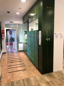 a row of green lockers in a hallway at Albergue Rincón del Peregrino Porriño-Pleno centro-City Center in Porriño
