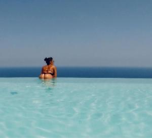斯克佩罗Hotel Antica Cascina Del Golfo的坐在海洋水中的女人