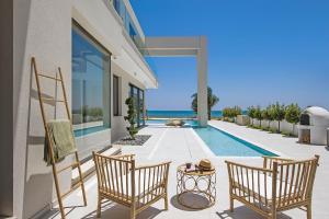 a patio with two chairs and a swimming pool at Eros Cyprus in Ayia Napa