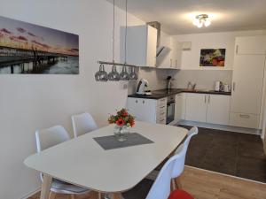 een keuken en eetkamer met een witte tafel en stoelen bij Apartment with parking garage in Metzingen