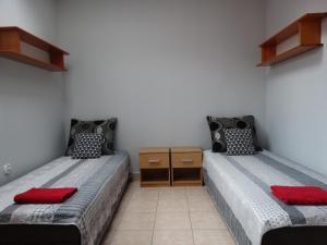 2 camas en una habitación con almohadas rojas en Trzy Korony Świecie, en Świecie