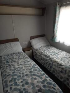 1 dormitorio con 2 camas y ventana en Haven Rockley Park,Lytchett Bay View, en Hamworthy