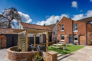 a garden with a patio with a table and chairs at Durham House Holiday Let, sleeps 26 with Croft and Hay Loft in Sedgefield