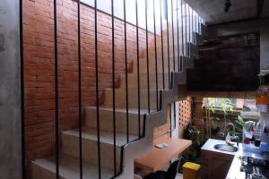 Una escalera en una habitación con una pared de ladrillo en Sunshine Vintage House en Ubud