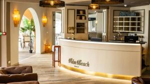 a hotel lobby with a reception counter and chairs at Palm Beach in Ajaccio
