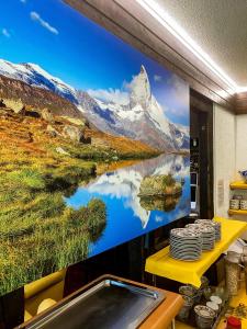 a wall mural of a mountain and a lake at Hotel Adonis in Zermatt