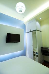 a bedroom with a bed and a tv on a wall at The One Vacation Home in Melaka