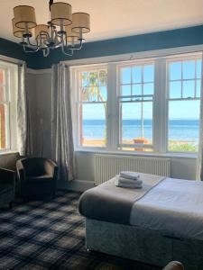 1 dormitorio con cama y vistas al océano en Burlington Guest House en Whiting Bay