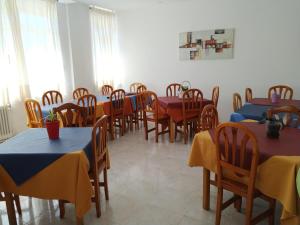 uma sala de jantar com mesas e cadeiras com mesas amarelas e azuis em Albergue Ciudad del Doncel em Sigüenza