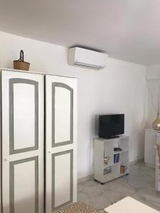 una camera con porta bianca e televisore di Le Dimore della Villa dei Sogni a Vulcano