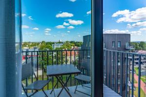 a balcony with a table and chairs and a view of the city at Artisa Riia Str 22A Luxury apartment in Tartu