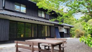einem Picknicktisch aus Holz vor einem Gebäude in der Unterkunft Cominka Hotel Shiki no Ie - Vacation STAY 89847 in Mitake